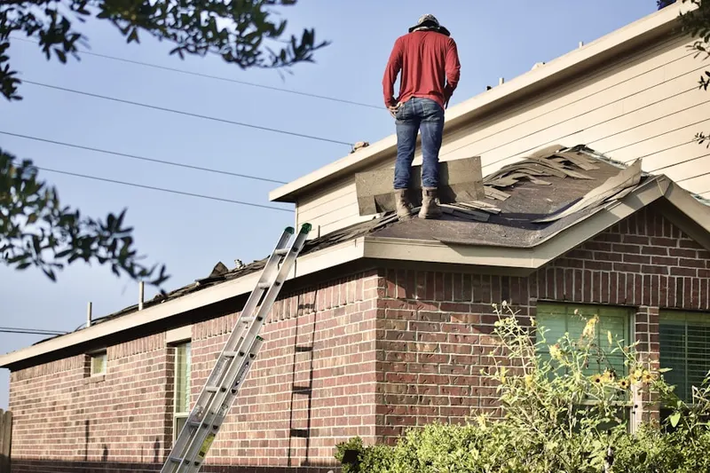 Professional roofer working on a residential roof in Mixville